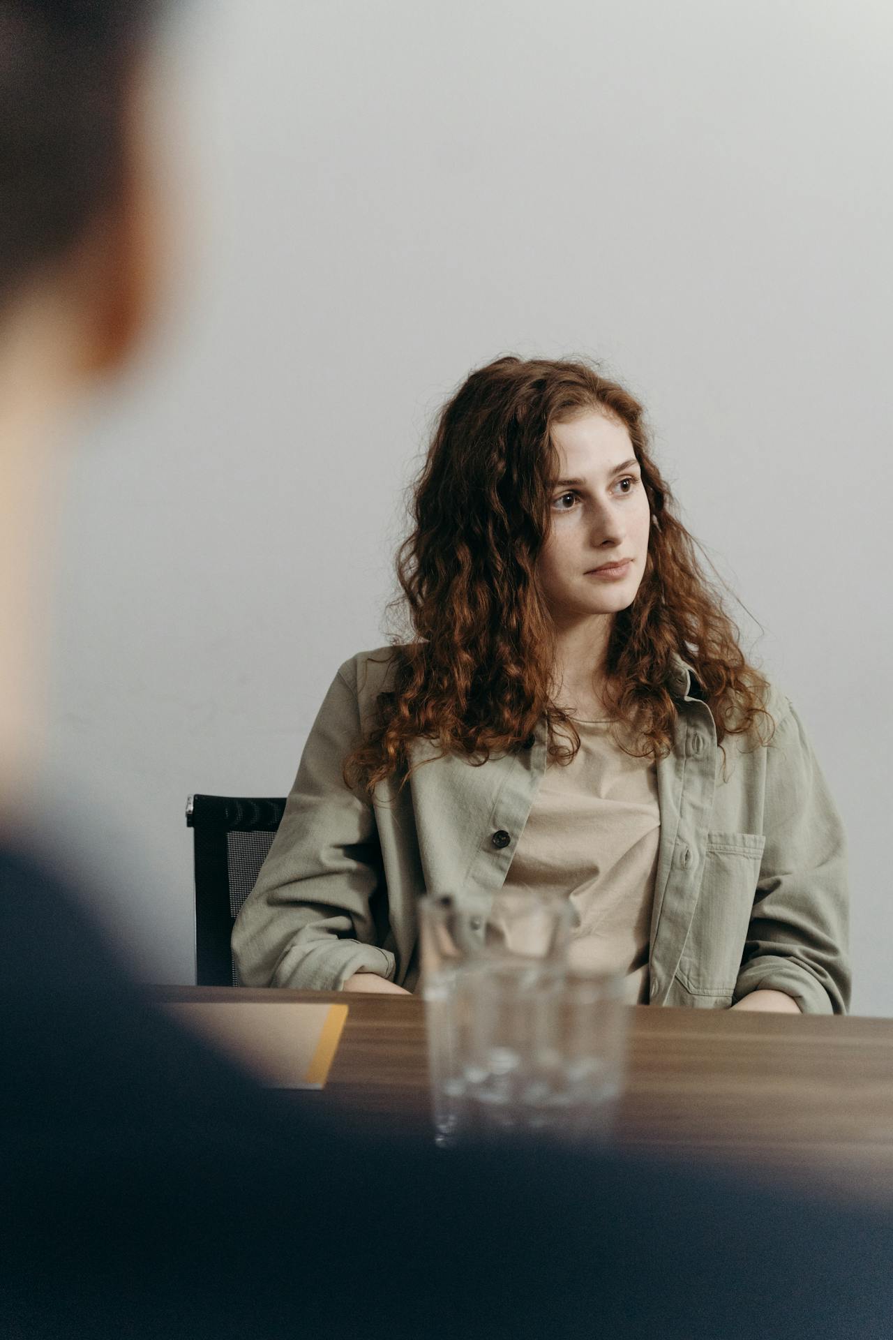 Vrouw in gesprek kijkt weg, omdat ze niet durft te zeggen wat ze voelt.