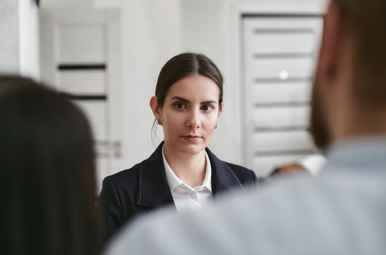 Vrouw twijfelend om iets te zeggen tijdens een gesprek met anderen.
