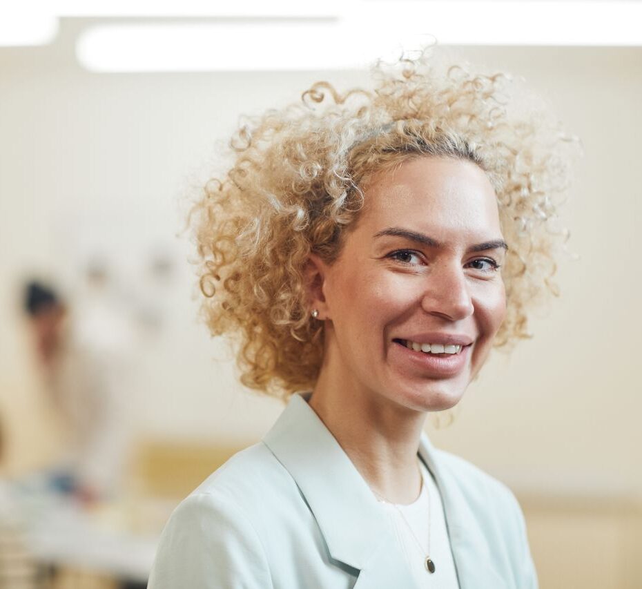 Professionele vrouw straalt zelfvertrouwen en persoonlijk leiderschap uit in een werkomgeving.